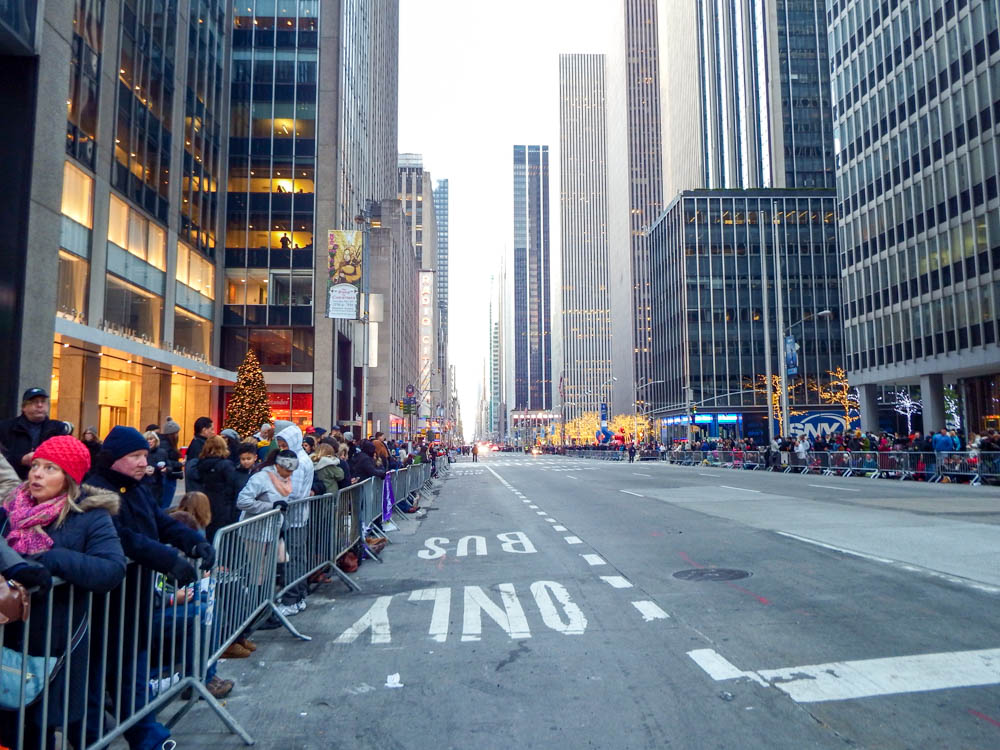 empty street in manhattan lined with lots of people