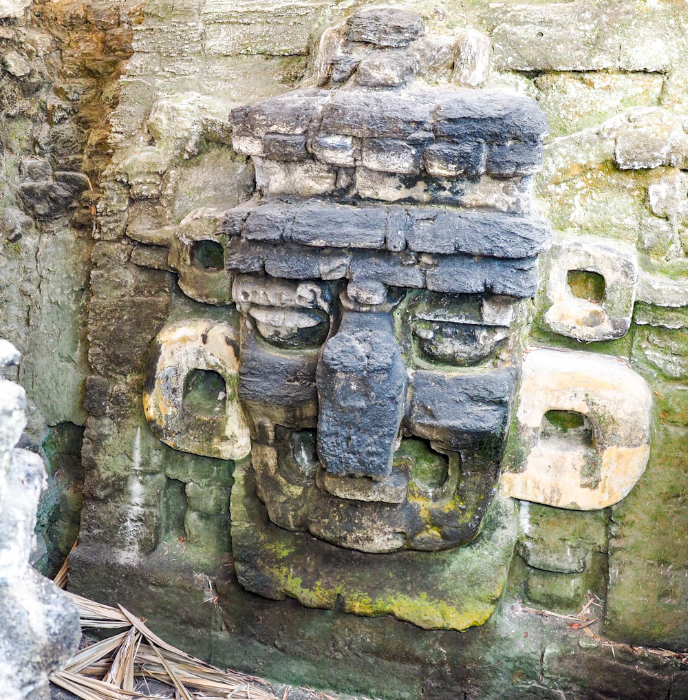 ancient maya face carving in rock on belize to tikal day trip