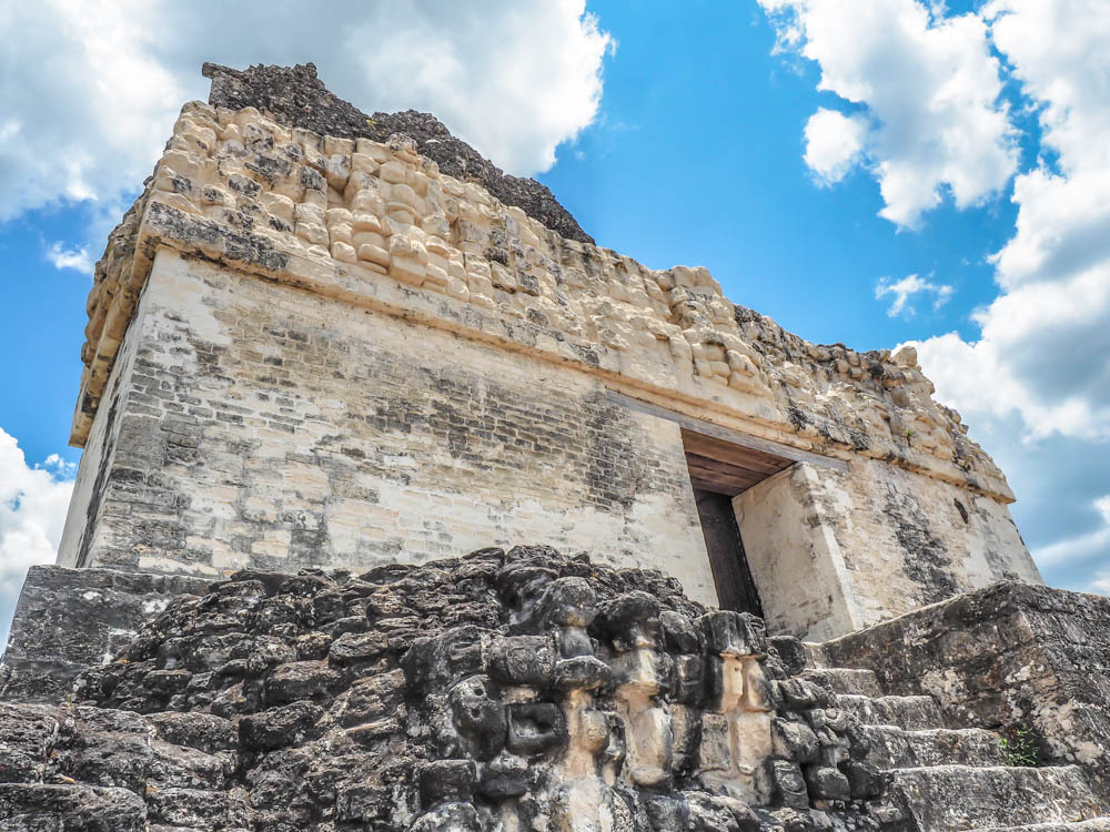 top of ancient temple against blue sky on belize to tikal day trip