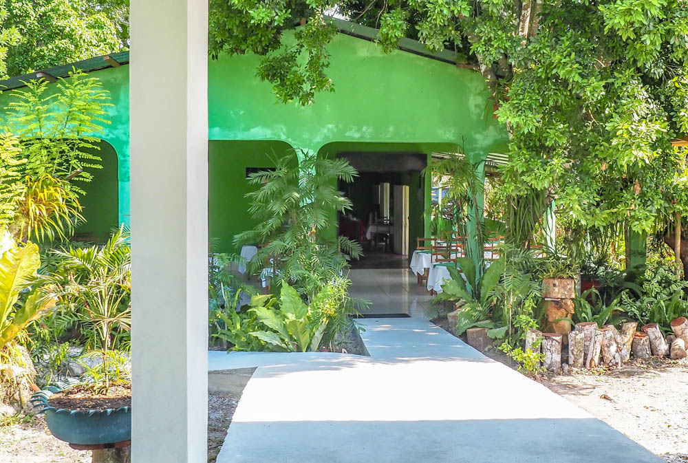 green building surrounded by trees on belize to tikal day trip