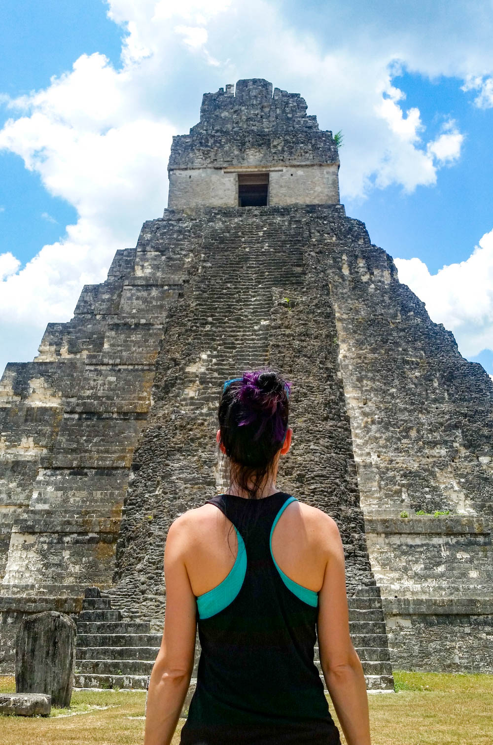 woman standing in front of and facing ancient temple on belize to tikal day trip