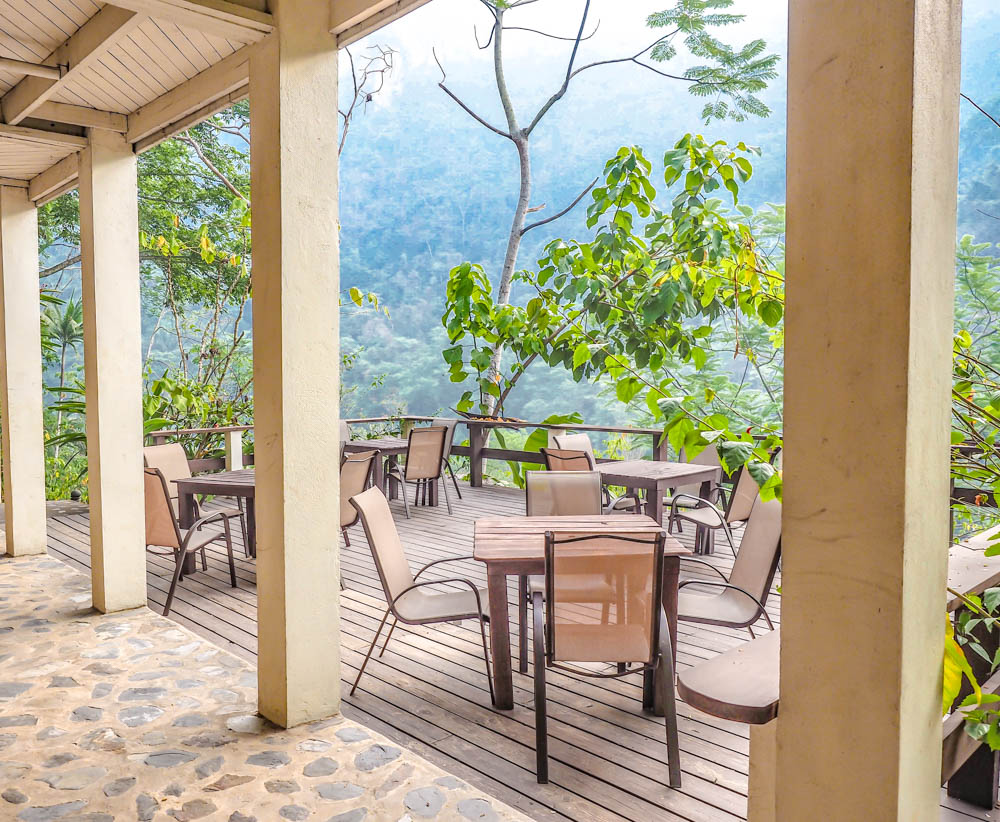 patio with tables and chairs next to the jungle at black rock lodge in belize