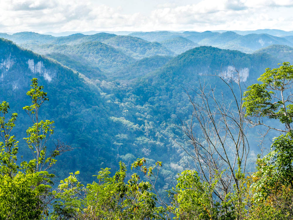 blue mountains in the distance from a mountain summit in belize