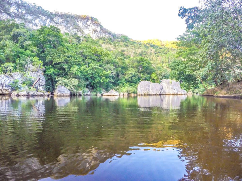 view from a river in the jungle with mountains in belize