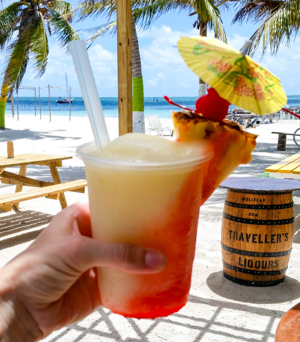 yellow and red frozen drink in front of the beach