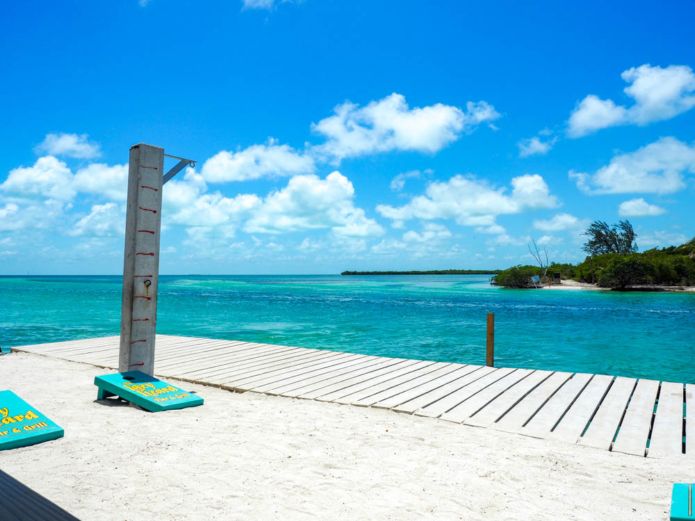 cornhole set on a deck next to a turquoise ocean