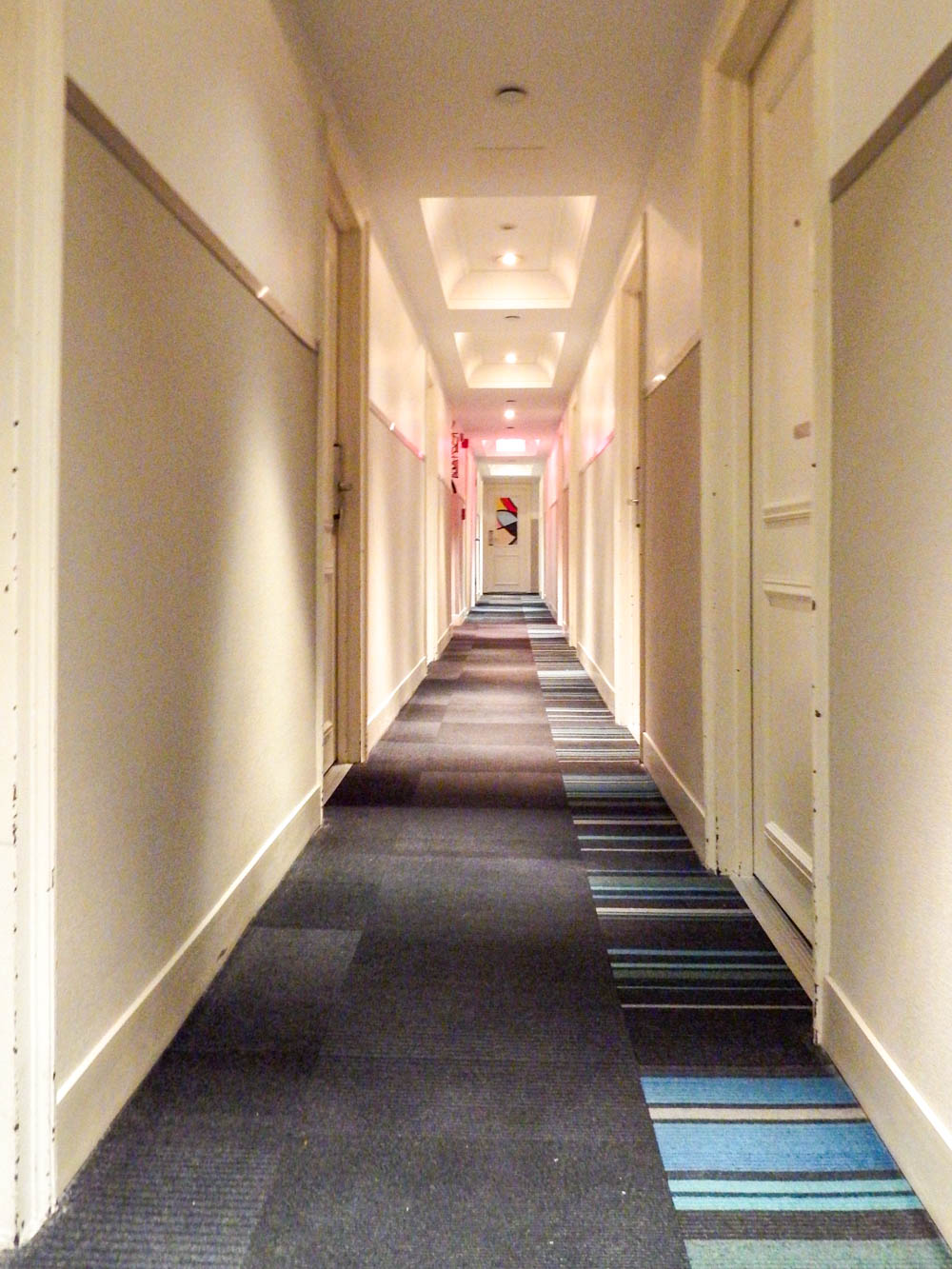 hotel hallway with beige walls and dark carpet