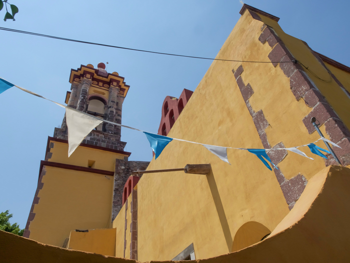 2 days in San Miguel de Allende travel tips | yellow church with flags #sanmigueldeallende #mexico #traveltips #timebudgettravel #sanmiguel #church