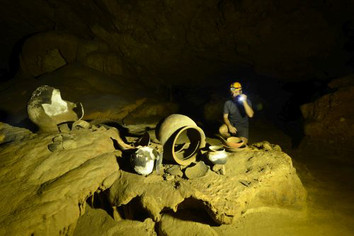 Man with flashlight in the ATM Cave / What to pack for the ATM Cave in Belize: What to wear, what shoes to wear, what to bring, and what to never, ever bring into the ATM Cave. 