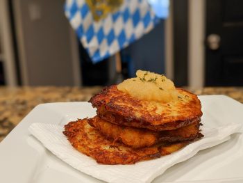 plate of potato pancakes with apple sauce in front of a bavarian flag