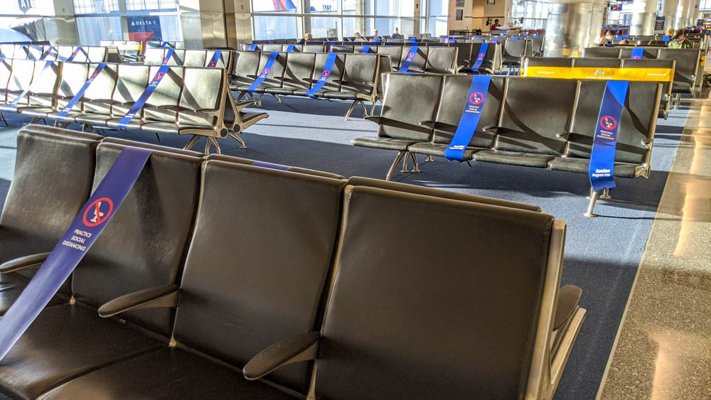 social distancing signs across seats in an empty airport terminal because of the pandemic