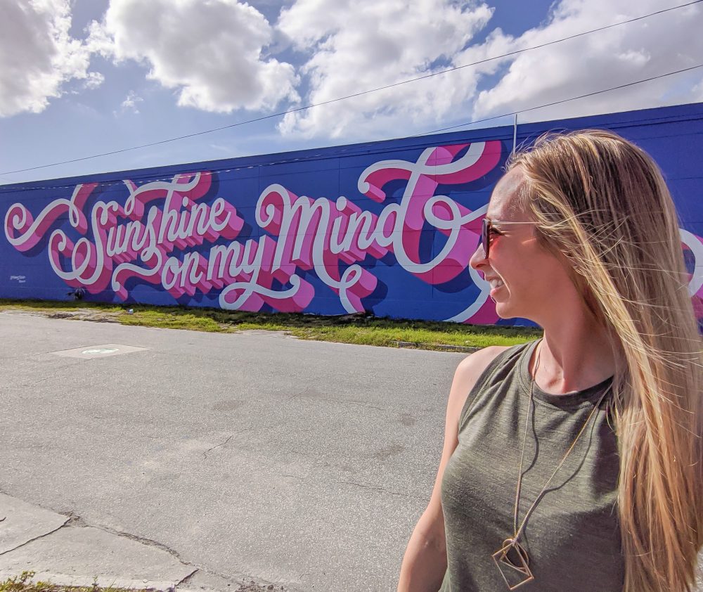 Sunshine On My Mind mural in St. Petersburg, Florida and me standing in front of it