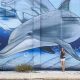 Large dolphin mural and me standing in front of it