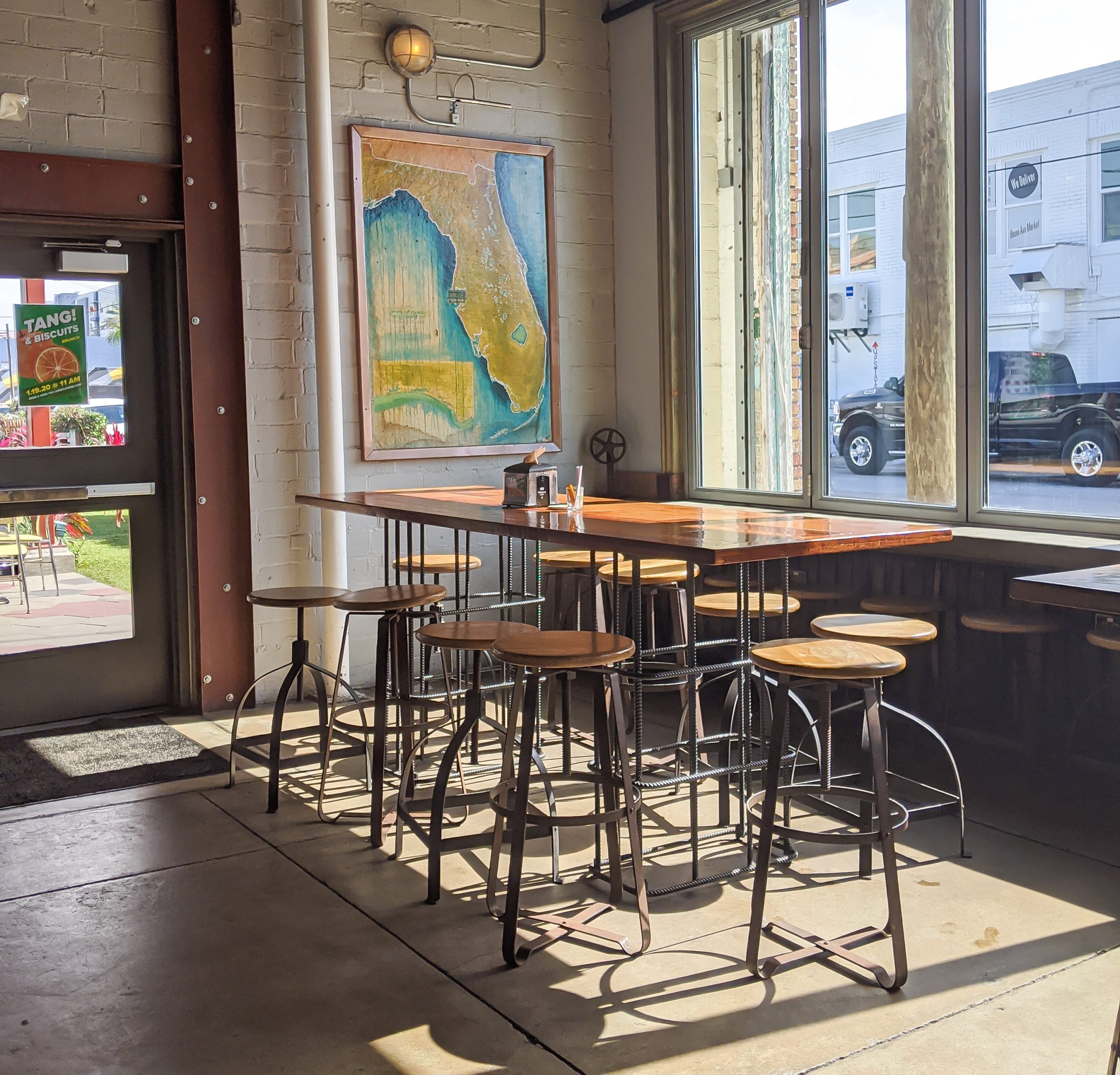 table and chairs in front of a florida map and some large windows