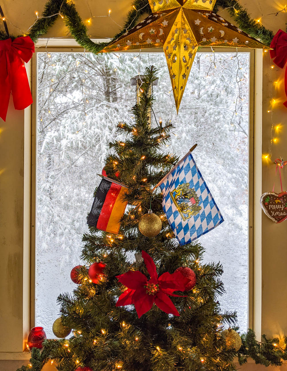 Christmas tree decorated with German flags surrounded by snow and stars
