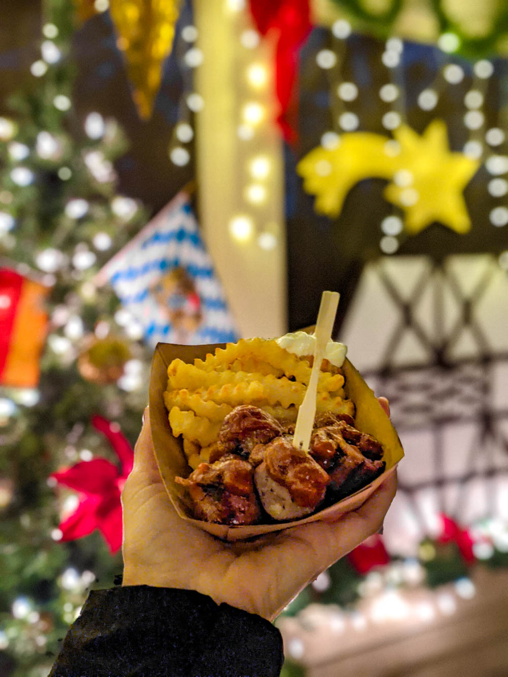 german currywurst and fries in front of bright christmas decorations