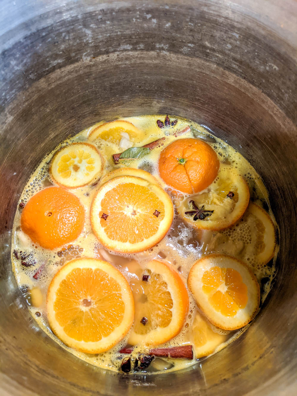 pot of gluhwein cooking - loaded with oranges