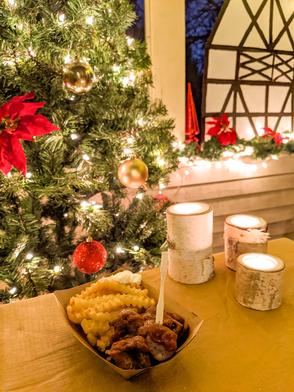 plate of currywurst and french fries in front of christmas decorations