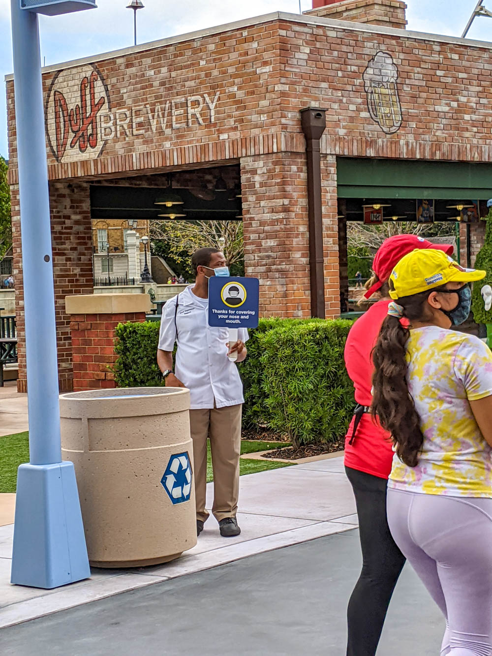 Employee holding mask sign at universal orlando during the pandemic