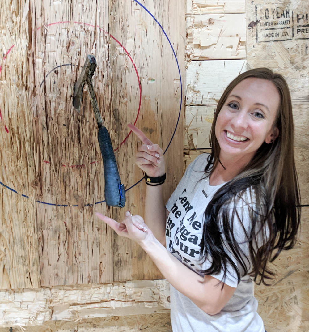 girl standing next to axe in a bullseye - things to do in orlando besides theme parks