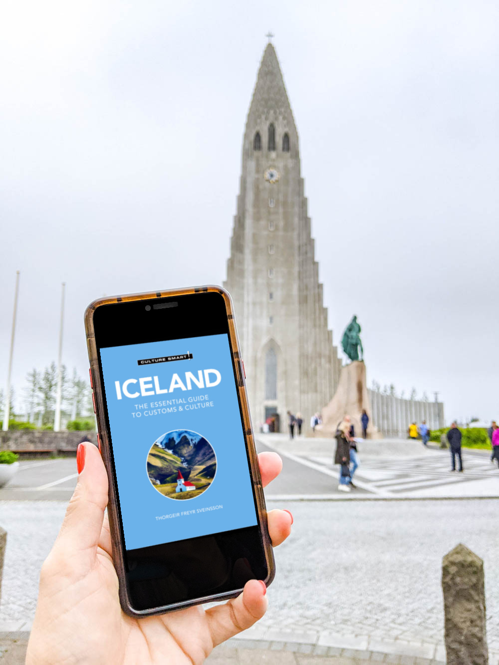 culture smart iceland cover page on a phone in front of reykjavik church