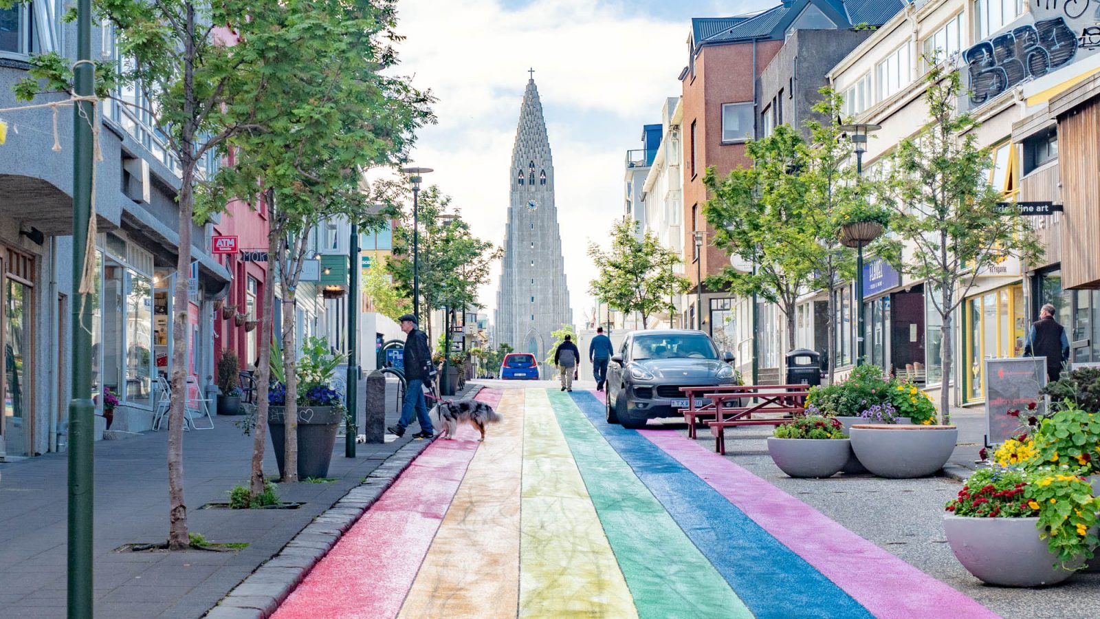 City street painted like a rainbow with a tall church at the end