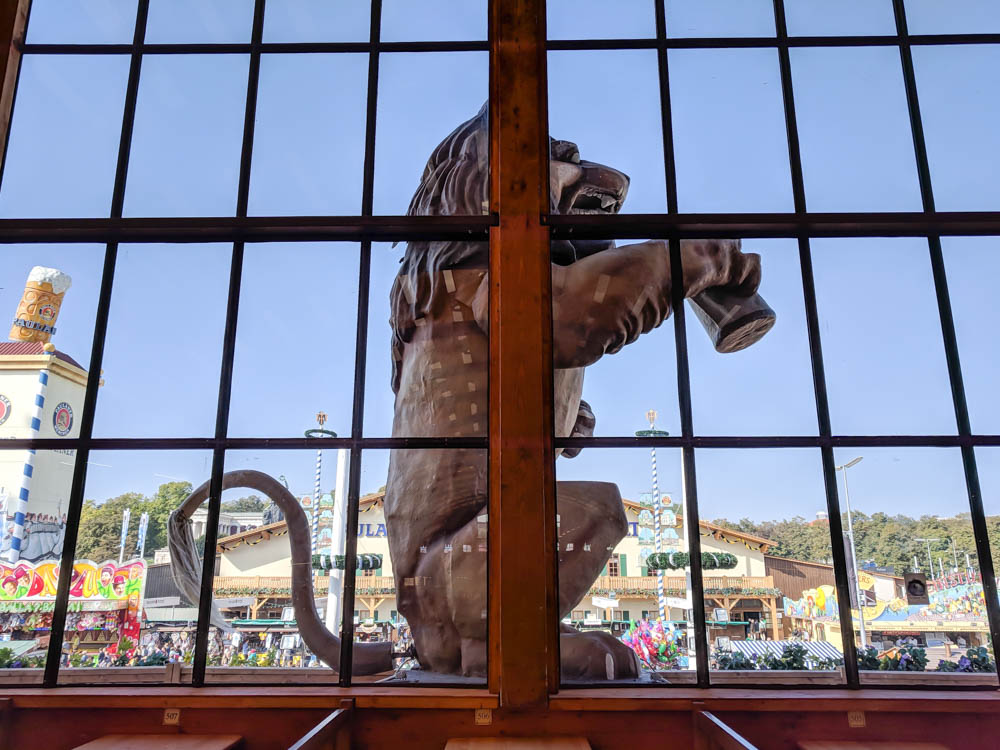 giant lion statue drinking a beer through a window