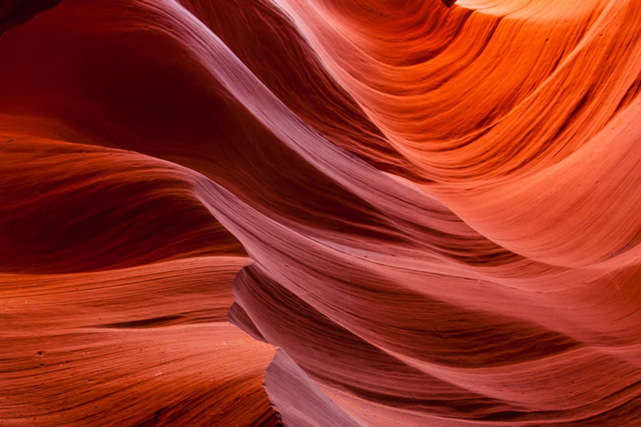 purple, orange, and red swirls of color in a slot canyon