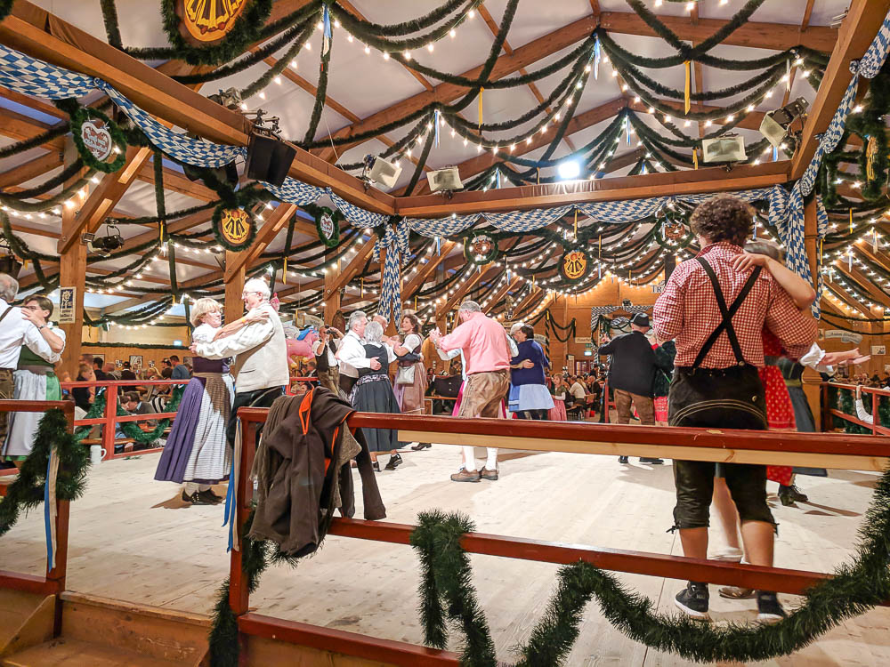 older couples in traditional outfits for oktoberfest dancing in a beer tent