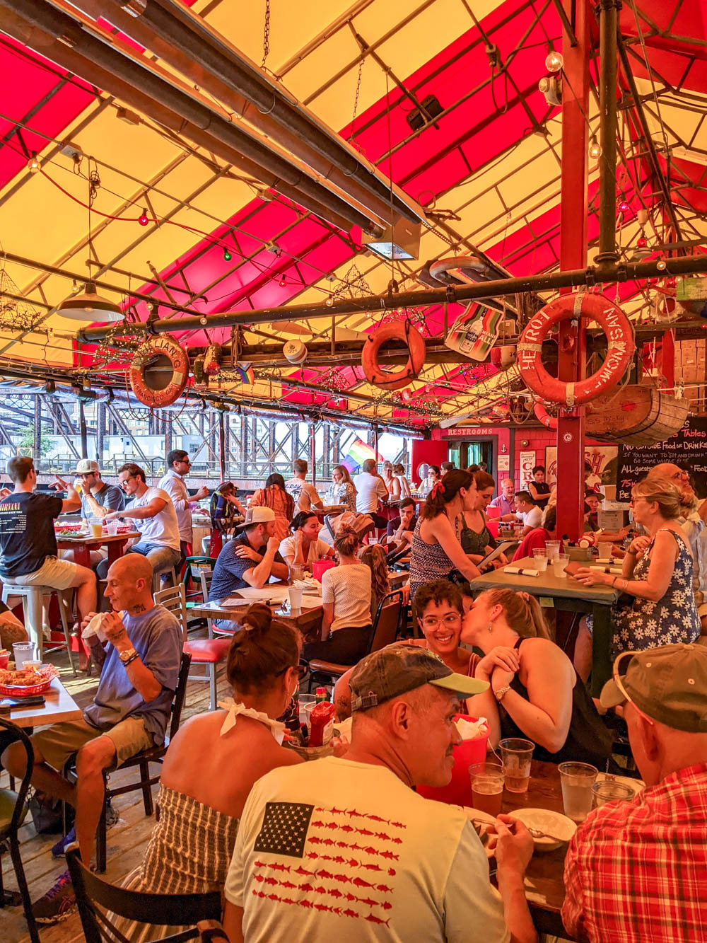 people inside a red and yellow striped tent eating