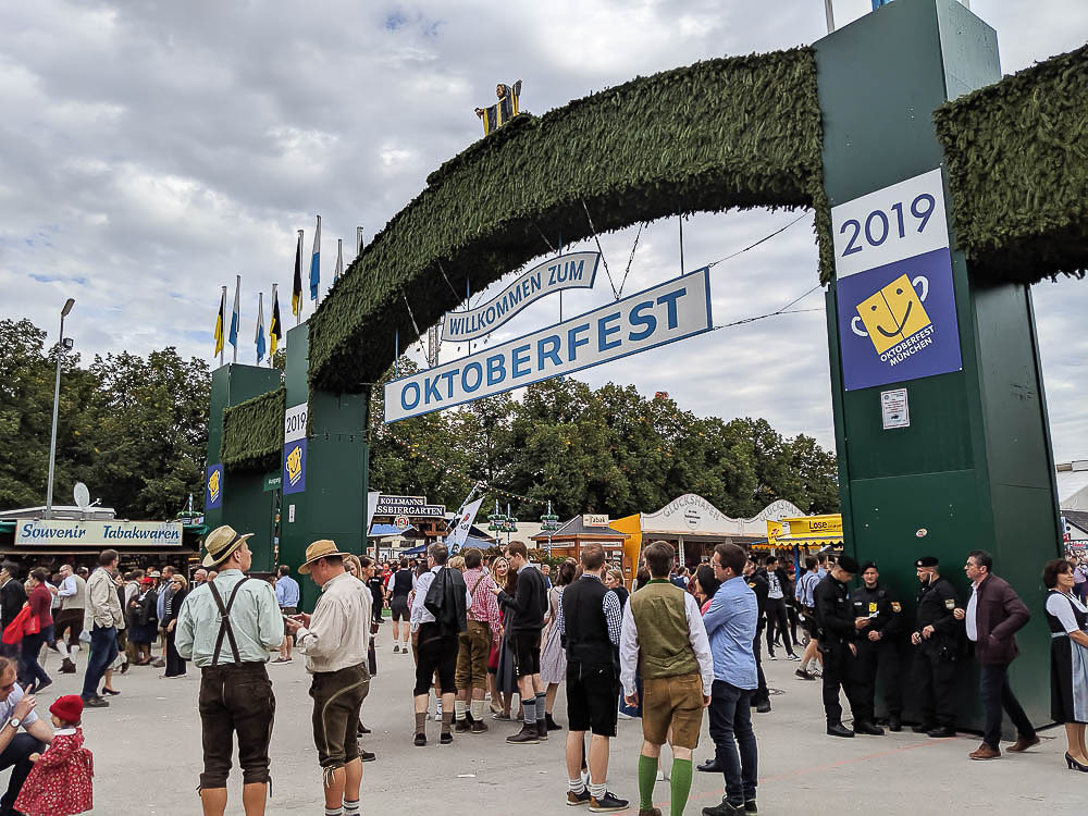 groups of people in lederhosen standing under the main entrance to oktoberfest in munich