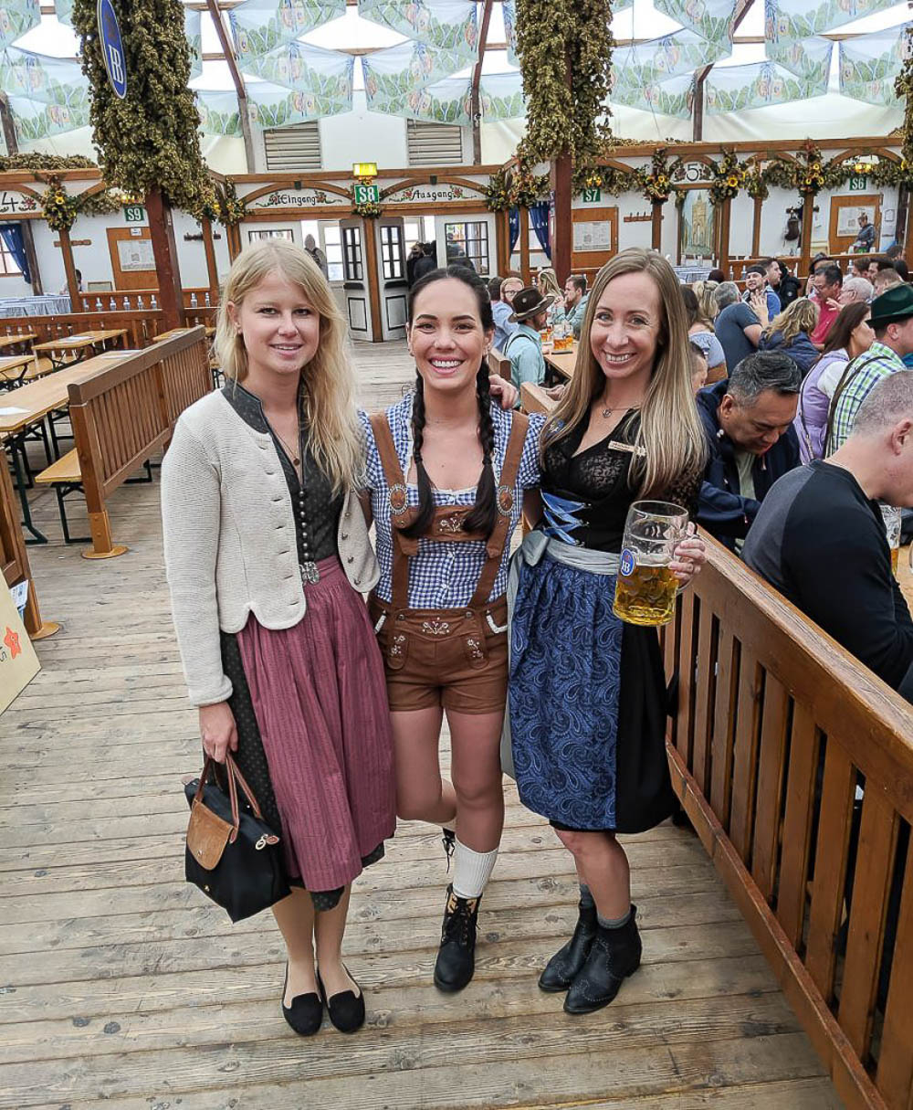 me and two friends in traditional oktoberfest outfits in a beer tent at oktoberfest in munich