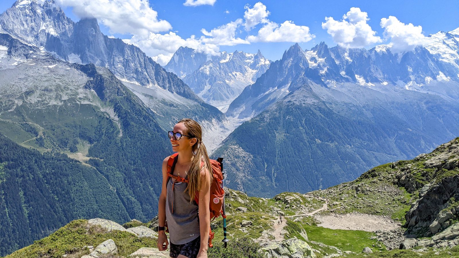 me hiking along a mountain trail while wearing an orange backpack