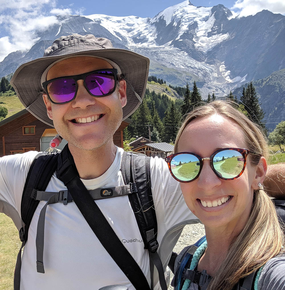 man and woman in bright sunglasses in front of a mountain