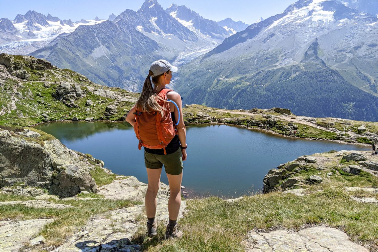 me standing on the edge of a mountain in front of a lake with an orange backpack