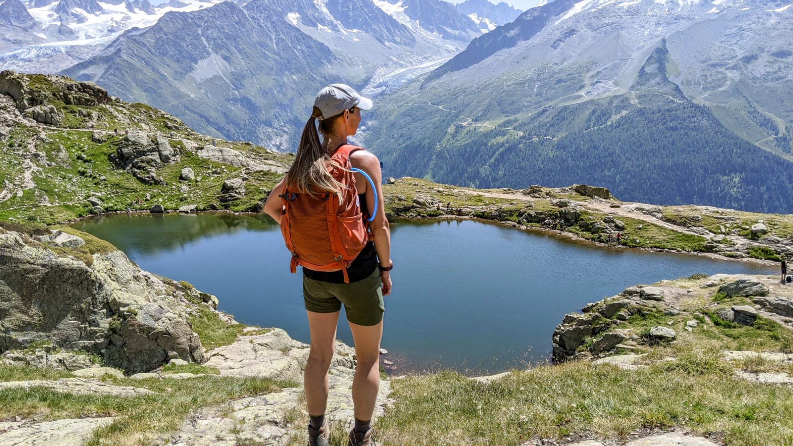 me standing on the edge of a mountain in front of a lake with an orange backpack
