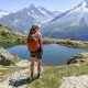 me standing on the edge of a mountain in front of a lake with an orange backpack