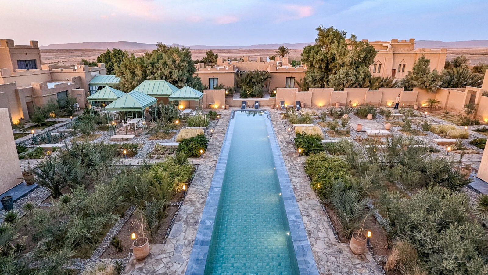 a sandcastle looking hotel with a pool down the middle as seen from above