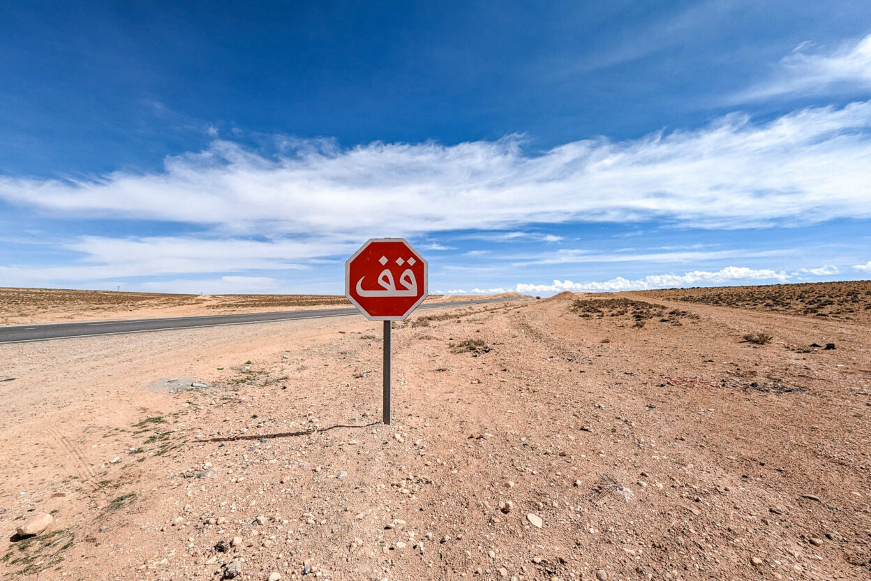 stop sign in the middle of nowhere under a blue sky