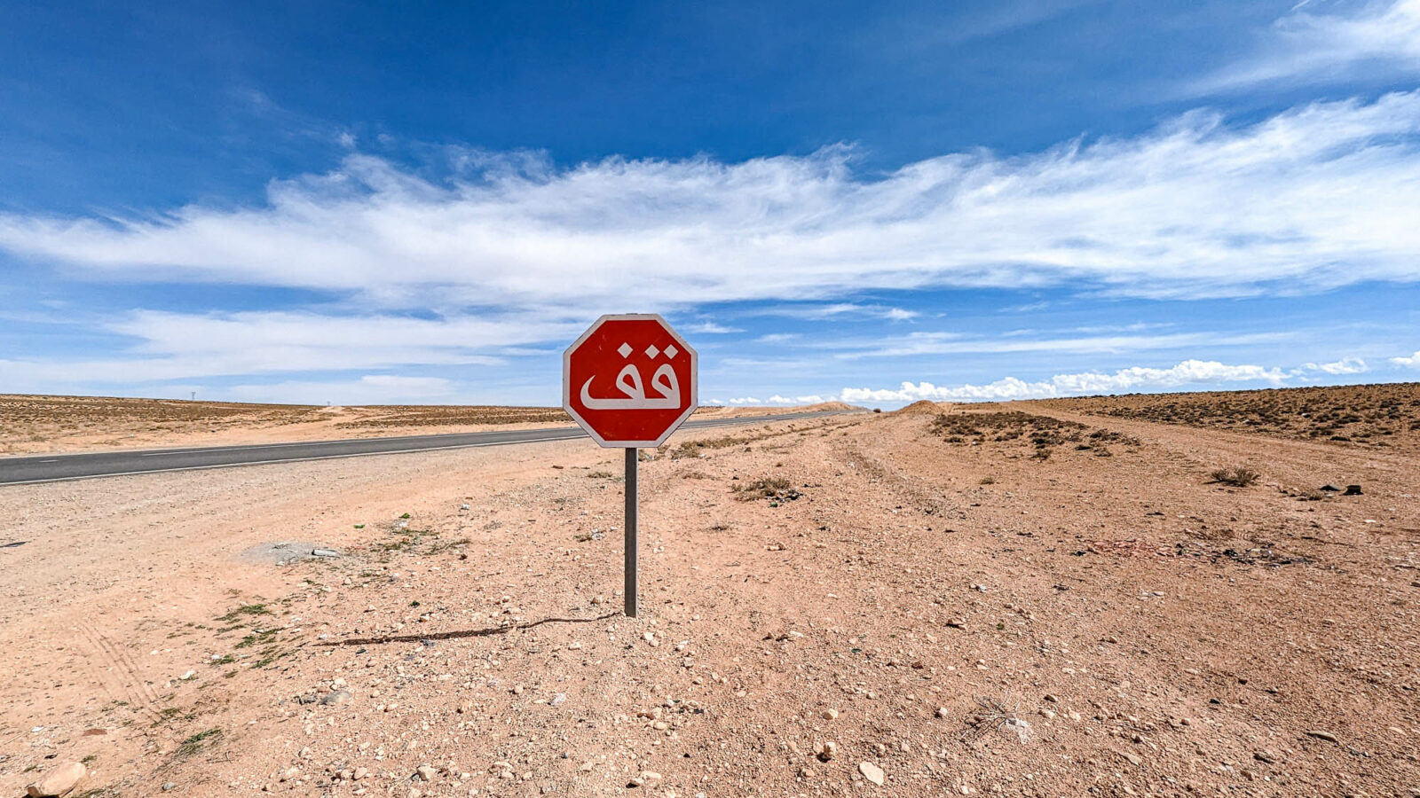 stop sign in the middle of nowhere under a blue sky