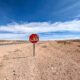 stop sign in the middle of nowhere under a blue sky