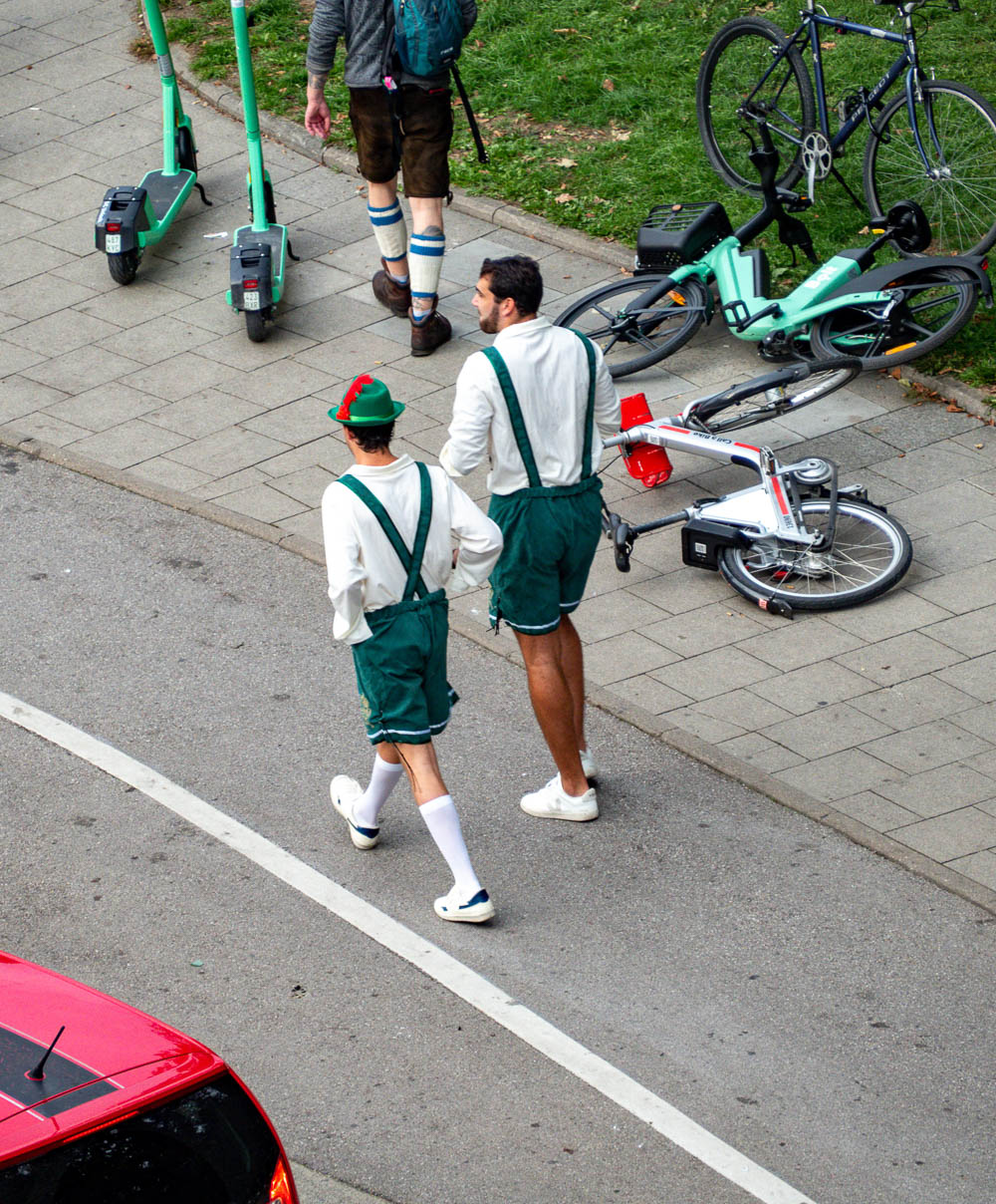 two men wearing fake green lederhosen and a peter pan hat