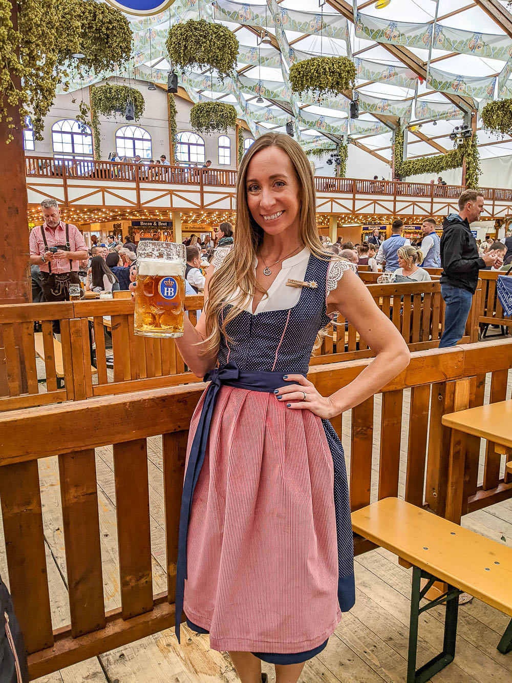 me in a pink and blue dirndl inside a beer tent at oktoberfest
