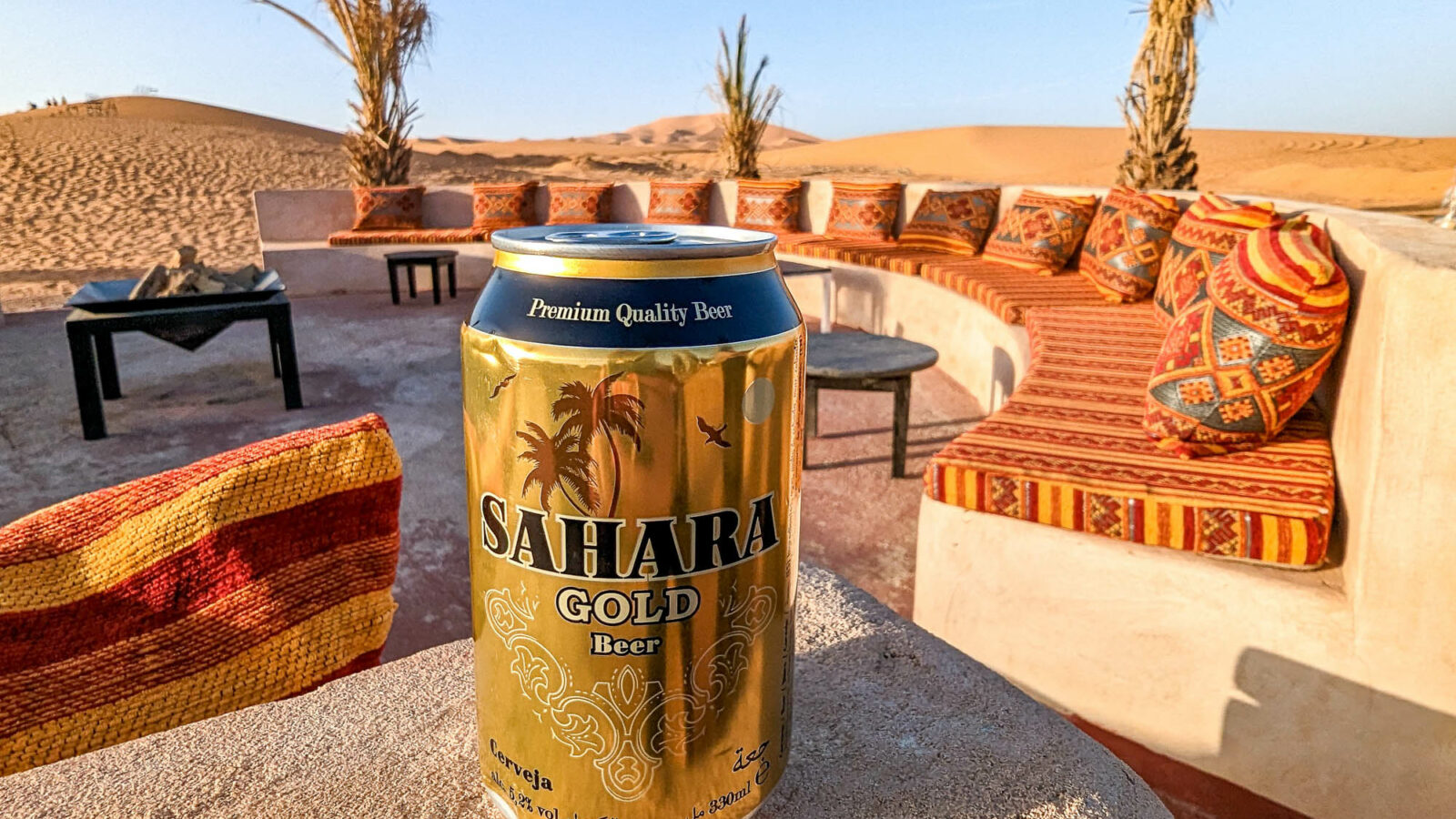 golden can of Sahara Gold beer on a concrete ledge in the desert