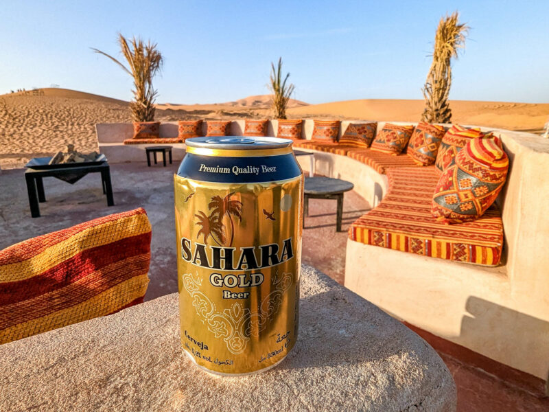 golden can of Sahara Gold beer on a concrete ledge in the desert