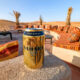 golden can of Sahara Gold beer on a concrete ledge in the desert