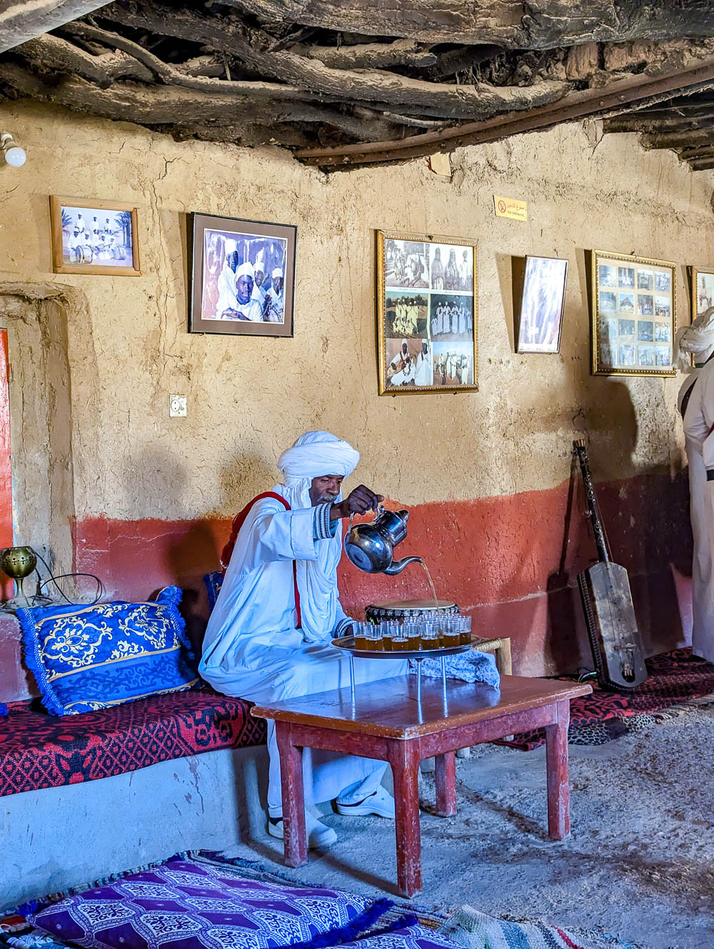 man in white robes pouring tea