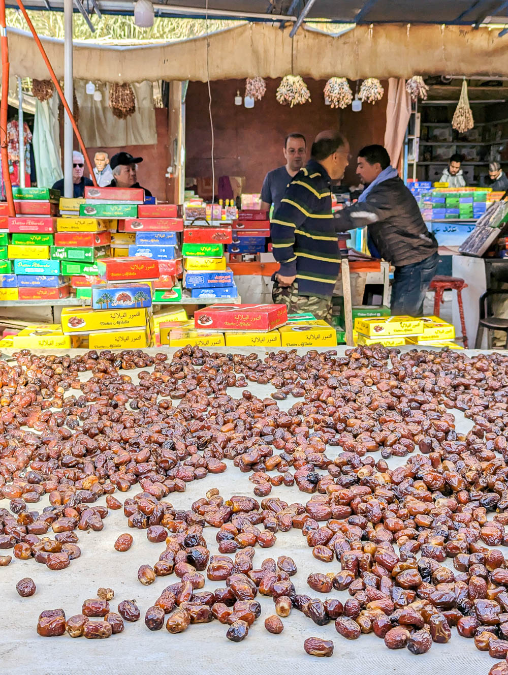 man standing behind a large table filled with dates