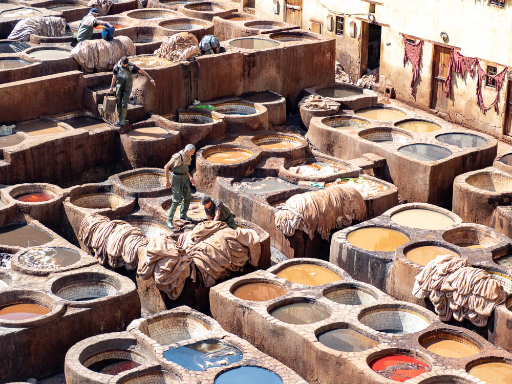 close up of men working in colorful dye vats
