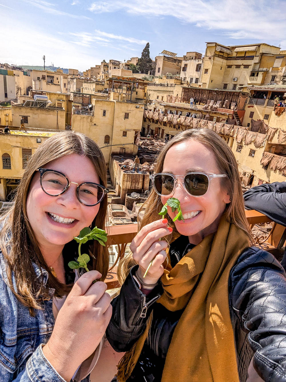 two women smelling mint leaves